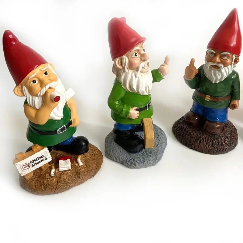 Three garden gnome figurines with red hats on a white background