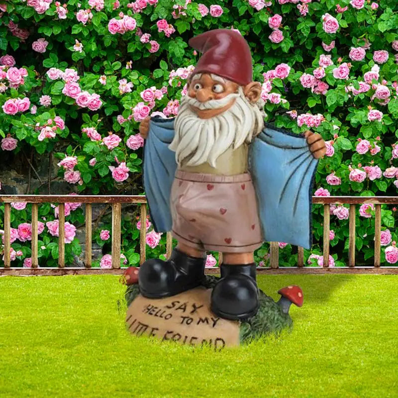 Gnome figurine with a message on a stone base in front of pink flowers