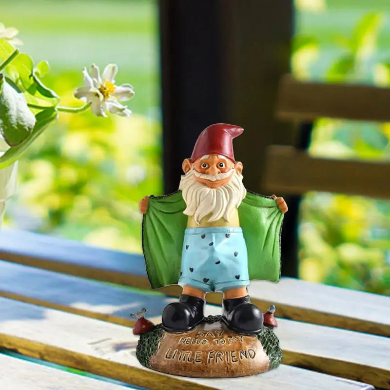Gnome figurine with a green hat and blue shorts on a wooden surface with a blurred natural background