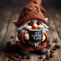 Gnome holding a mug with 'It's Coffee Time' text surrounded by coffee beans on a wooden surface.