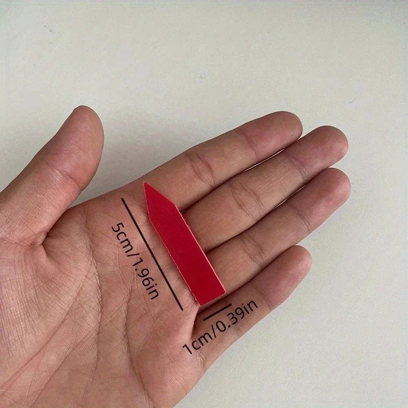 Red lipstick stick held in a hand with measurements indicated